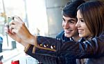 Young Couple Using Mobile Phone In Cafe Stock Photo