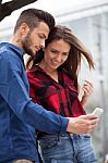 Young Couple Using Smart Phone Stock Photo