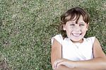 Young Cute Girl Lying On The Grass Stock Photo