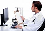 Young Ethnic Doctor Looking At Medical Report Deeply Stock Photo