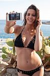 Young Female At The Seashore Taking Selfie Stock Photo