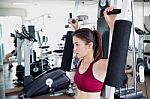 Young Fitness Woman Executed Exercise With Exercise-machine In Gym Stock Photo