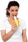 Young Girl Eating Banana Stock Photo