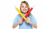 Young Girl Holding Big Red And Yellow Pencils Stock Photo