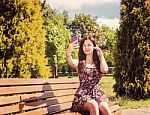 Young Girl Making Selfie Sitting On A Park Bench Stock Photo