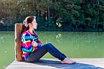 Young Girl Sitting On A Pier Stock Photo