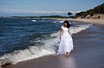 Young Girl Walking Along The Seashore Stock Photo