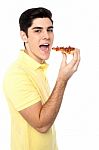 Young Guy With A Slice Of Pizza In Hand Stock Photo