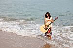 Young lady Playing Guitar at Beach Stock Photo