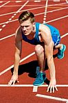 Young Male Sprinter In Starting Blocks Stock Photo