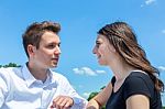 Young Man And Woman In Love Conversating With Blue Sky Stock Photo