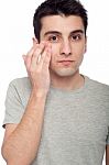 Young Man Applying Eye Cream Stock Photo