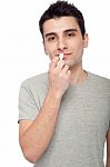 Young Man Applying Lip Balm Stock Photo