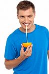 Young Man Drinking Orange Juice Stock Photo