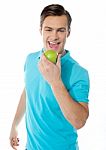 Young Man Eating Green Apple Stock Photo