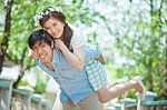 Young Man Giving A Piggy Back To His Girlfriend Stock Photo