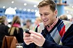 Young Man In Cafe And Using His Mobile Phone Stock Photo