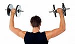 Young Man lifting Dumbbells Stock Photo