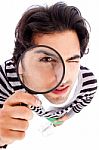 Young Man Looking Up With A Magnifying Glass Stock Photo