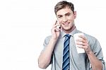 Young Man On Call, Enjoying His Refreshment Stock Photo