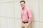 Young Man Posing Smartly Against Wall Stock Photo