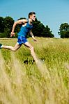 Young Man Running Through Meadows Stock Photo