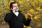 Young Man Talking On Cellphone At Park Stock Photo