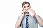 Young Man Using His Mobile While Drinking Coffee Stock Photo