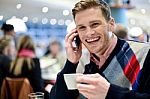 Young Man Using Mobile Phone In Cafe Stock Photo