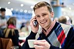 Young Man Using Mobile Phone In Cafe Stock Photo