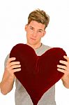 Young Man With Heart Shaped Pillow Stock Photo