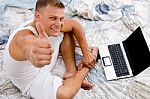 Young Man With Thumbs Up And Laptop Stock Photo