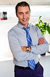 Young Manager In Formals Standing With Arms Crossed Stock Photo