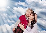 Young Mother And Her Little Daughter Look Up On A Background Clo Stock Photo