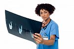 Young Serious Lady Surgeon Holding X-ray Sheet Stock Photo