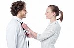 Young Woman Adjusting Her Husband's Tie Stock Photo