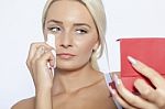 Young Woman Clean Face With Wet Wipes, Looking On Mirror In Hand Stock Photo