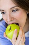 Young Woman Eating Green Apple Stock Photo