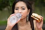 Young Woman Enjoying A Chicken Burger Stock Photo