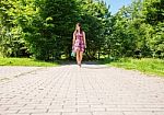 Young Woman Goes Barefoot On The Sidewalk Stock Photo