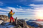 Young Woman Hiker Taking Photo With Smartphone On Mountains Peak In Winter Stock Photo