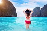 Young Woman In Red Bikini Sitting On The Beach Stock Photo