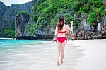 Young Woman In Red Bikini Sitting On The Beach Stock Photo