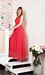 Young Woman In Red Dress Standing On The Stairs Stock Photo