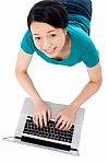 Young Woman Lying On Floor Using Laptop Stock Photo