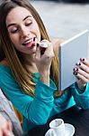 Young Woman Painting Her Lips With A Digital Tablet In A Coffee Stock Photo