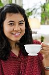 Young Woman Sipping Tea From A Cup Stock Photo