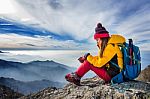 Young Woman Sitting On The Hill Of High Mountains Stock Photo