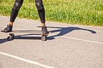 Young Woman Skateboarding In The Park Stock Photo