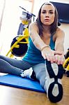 Young Woman Stretching Her Leg To Warm Up In The Gym Stock Photo